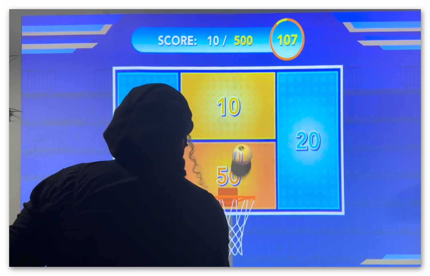 Live basketball gameplay showing players shooting at Ball Wall Arena interactive wall targets